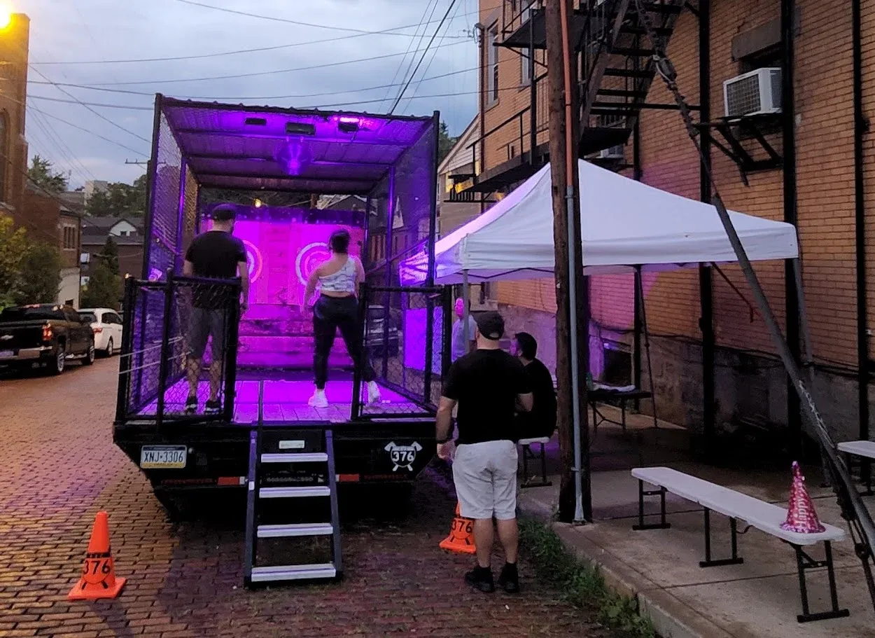 Guests throwing at an evening event beside a brick building