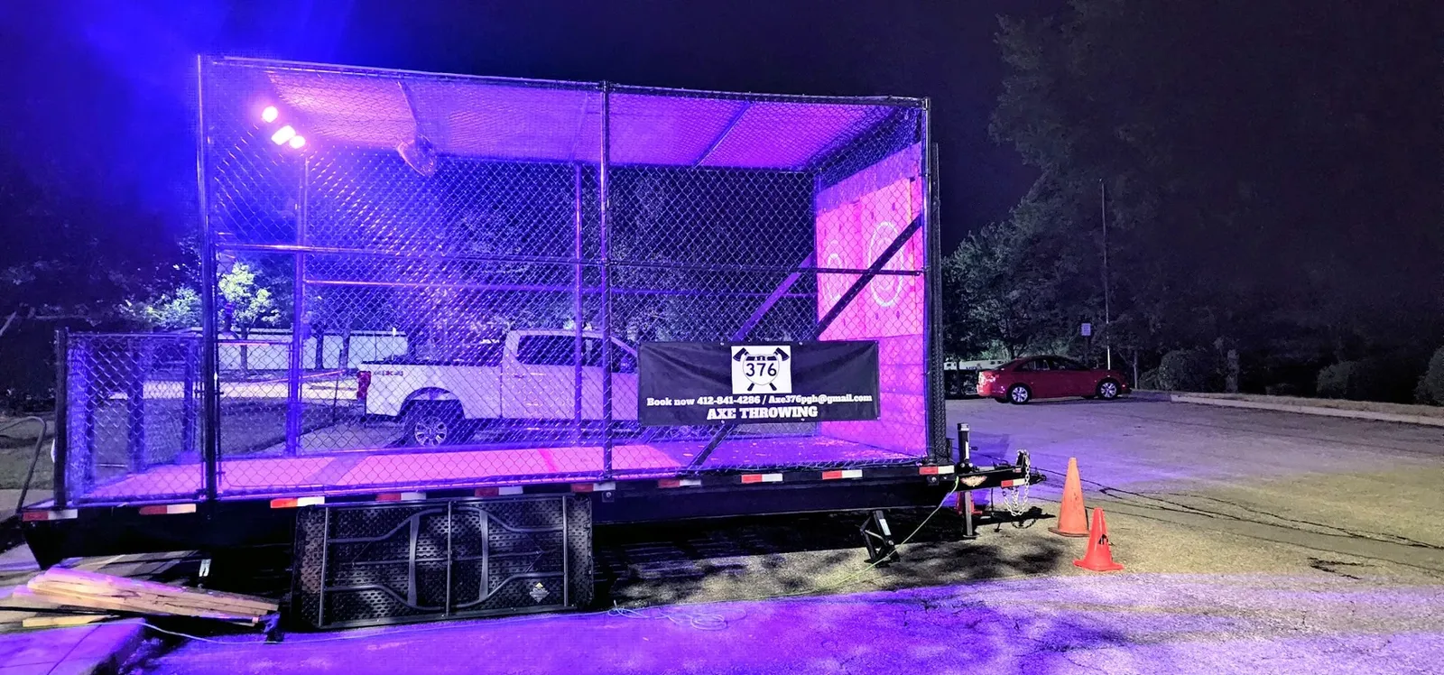 Wide view of the trailer glowing purple at night