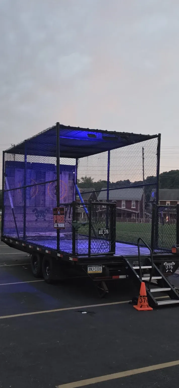 The AXE 376 trailer lit up in a parking lot at dusk